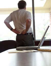 Worker in an office suffering discomfort because of back related illness
