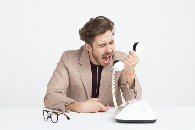 employee shouting into telephone